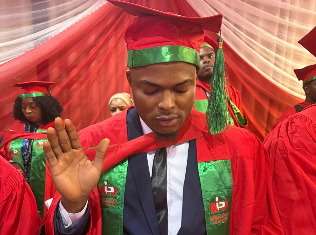 Ayobami Eruobami receiving his NIPR induction certificate in Abuja